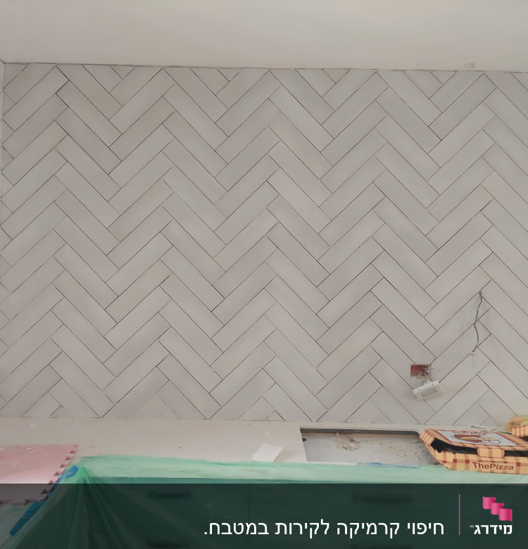 קיר אריחים בהתקנה עם שקעים חשמליים פתוחים